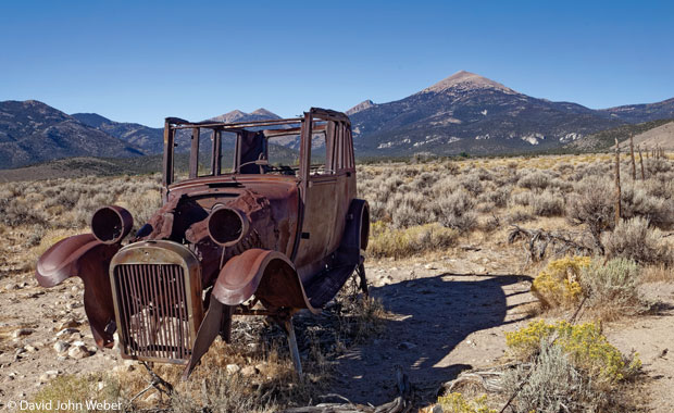 A rusted-out historical car with Wheeler Peak in the background at Great Basin National Park