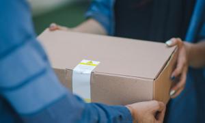 Mann übergibt Paket an Frau