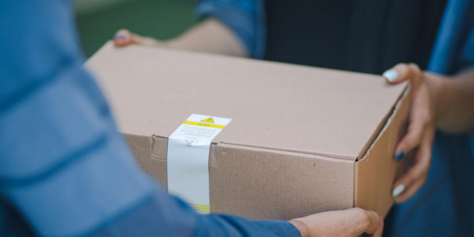 Mann übergibt Paket an Frau