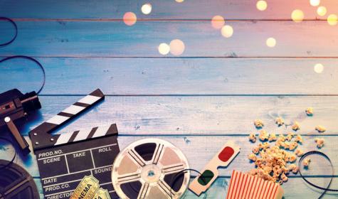 Camera with clapperboard, tickets, rolls, 3D glasses and popcorn